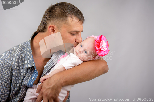 Image of Happy dad kissing a two-month baby daughter