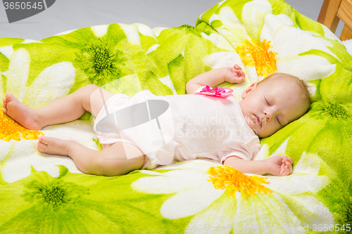 Image of The two-month baby sleeps happily in bed