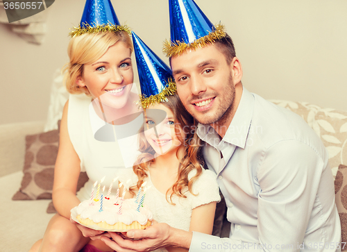 Image of smiling family in blue hats with cake