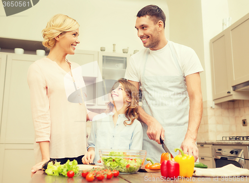 Image of happy family making dinner in kitchen