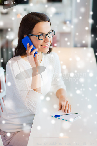 Image of smiling woman calling on smartphone at cafe