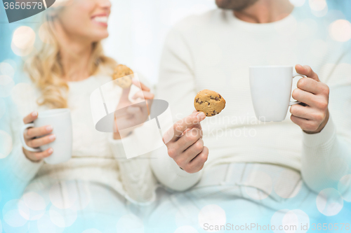 Image of close up of happy couple with cookies and tea cups