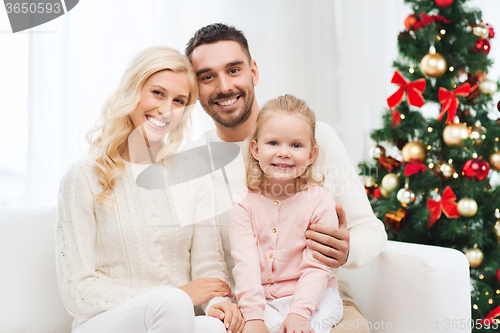 Image of happy family at home with christmas tree