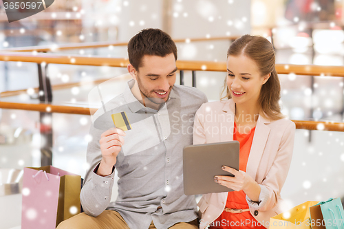 Image of couple with tablet pc and credit card in mall