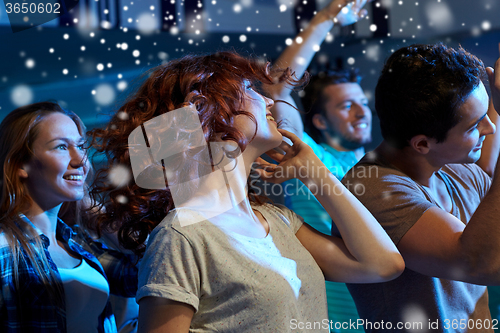 Image of happy friends dancing at night club