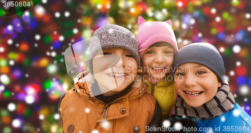 Image of happy children over snow and christmas lights