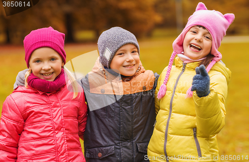 Image of group of happy children hugging in autumn park