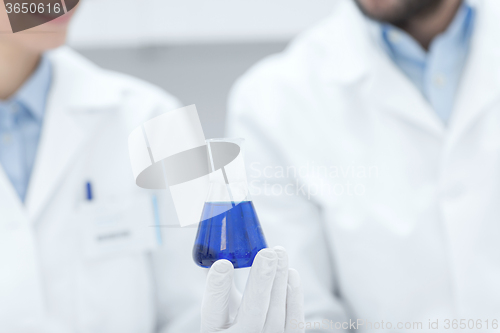 Image of close up of scientists with test tube in lab