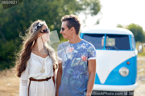 Image of smiling young hippie couple over minivan car