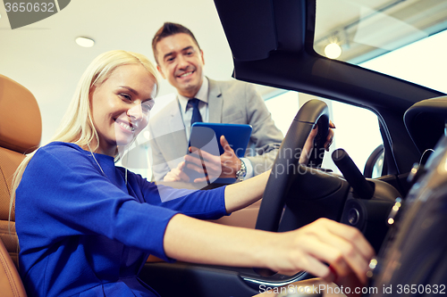 Image of happy woman with car dealer in auto show or salon