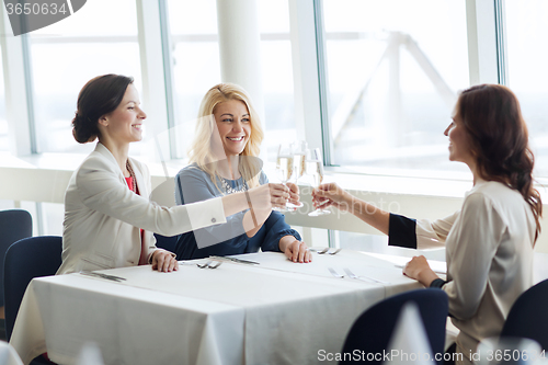 Image of happy women drinking champagne at restaurant