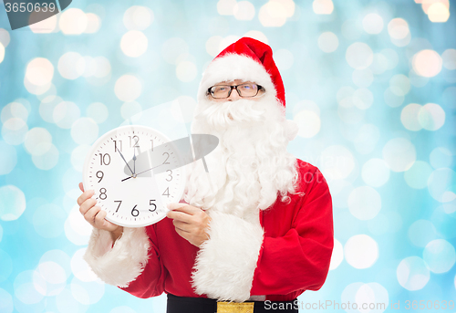 Image of man in costume of santa claus with clock