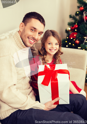 Image of smiling father and daughter holding gift box