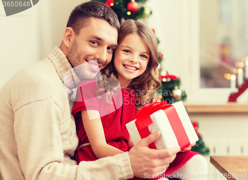 Image of smiling father and daughter holding gift box