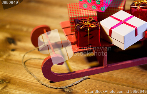 Image of close up of christmas gift boxes on wooden sleigh