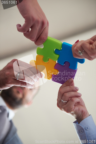 Image of business people group assembling jigsaw puzzle