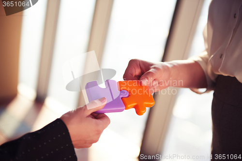 Image of business people group assembling jigsaw puzzle