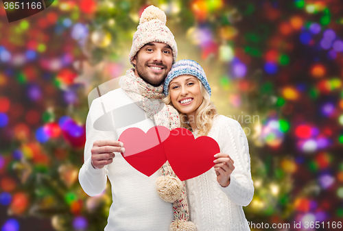 Image of smiling couple in winter clothes with red hearts