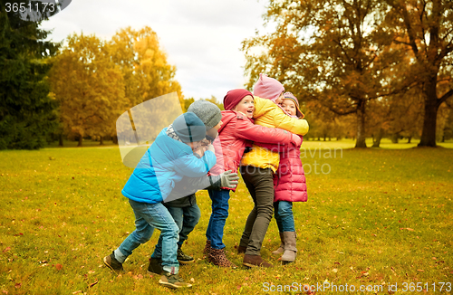 Image of group of happy children hugging in autumn park