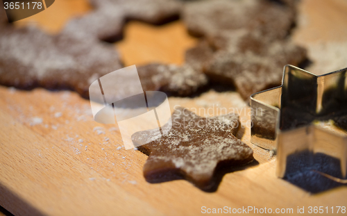 Image of close up of ginger dough, molds and flour on board