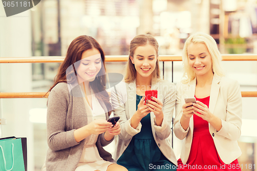 Image of happy women with smartphones and shopping bags