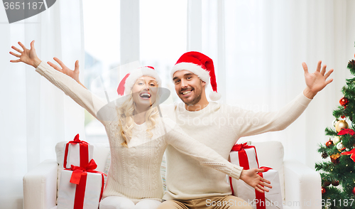 Image of happy couple at home with christmas gift boxes