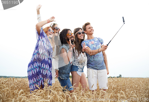 Image of hippie friends with smartphone on selfie stick