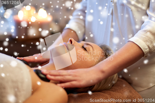 Image of close up of woman having hot stone massage in spa