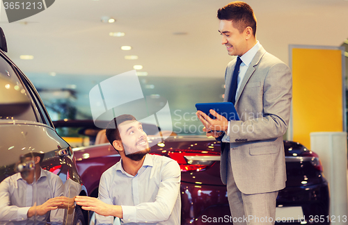 Image of happy man with car dealer in auto show or salon