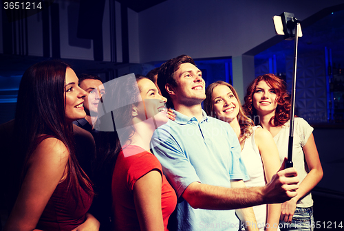 Image of friends with smartphone taking selfie in club