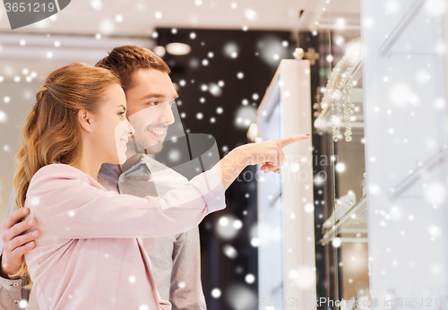 Image of couple looking to shopping window at jewelry store