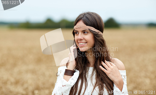 Image of smiling young hippie woman on cereal field