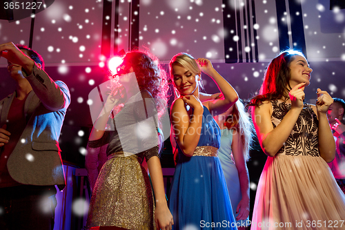 Image of smiling friends dancing in club