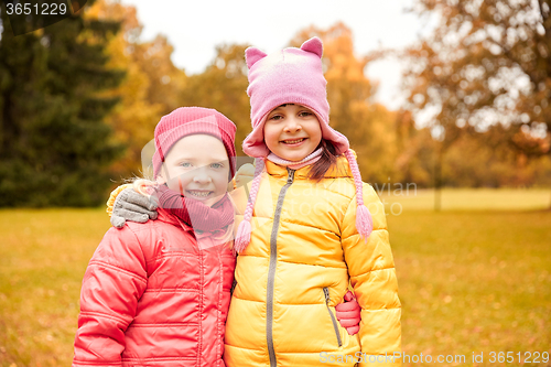 Image of two happy little girls hugging in autumn park