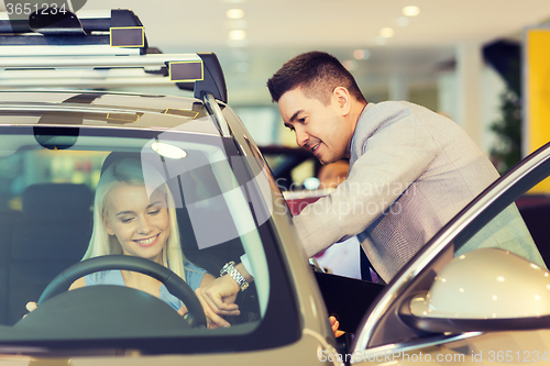 Image of happy woman with car dealer in auto show or salon