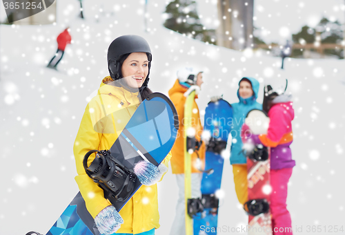 Image of happy friends in helmets with snowboards