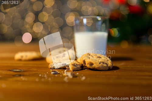 Image of close up of cookies and milk over christmas lights