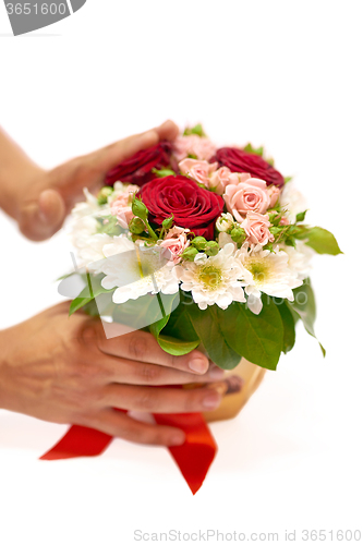 Image of Human hands standing a pot with flowers