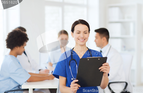 Image of happy doctor over group of medics at hospital