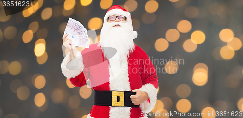 Image of man in costume of santa claus with euro money