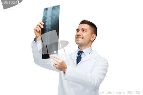 Image of smiling male doctor in white coat looking at x-ray