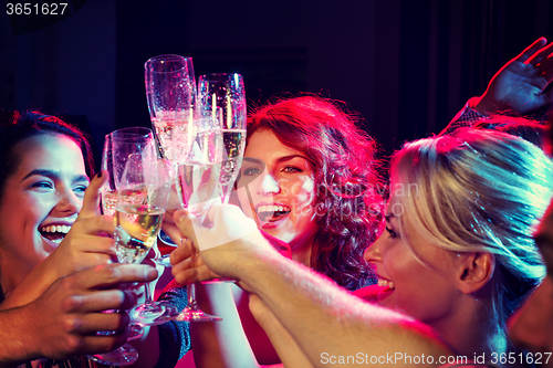 Image of smiling friends with glasses of champagne in club