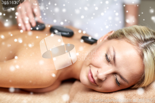 Image of close up of woman having hot stone massage in spa