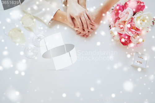 Image of close up of lesbian couple hands and wedding rings