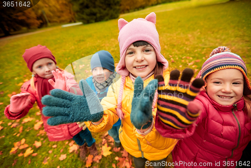 Image of happy children waving hands in autumn park