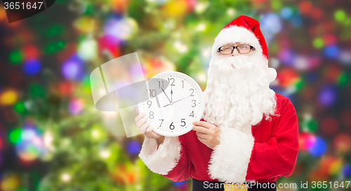 Image of man in costume of santa claus with clock