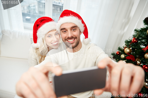 Image of couple taking selfie with smartphone at christmas