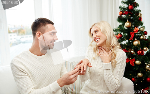 Image of man giving engagement ring to woman for christmas