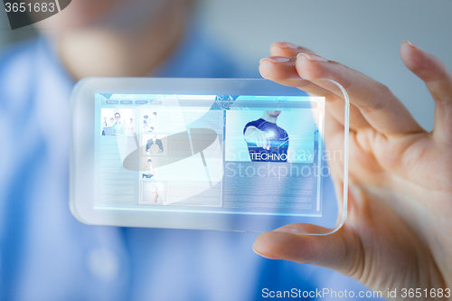 Image of close up of woman with transparent smartphone