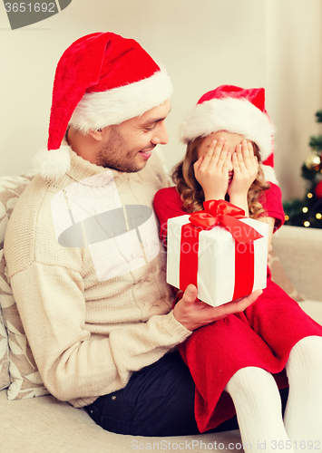 Image of smiling daughter waiting for a present from father